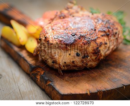 juicy steak with potatoes, tomatoes and herbs on a cutting board