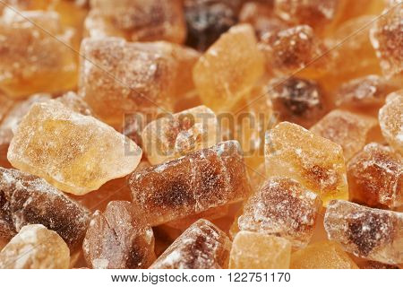 Surface coated with multiple large brown rock sugar crystals as a background composition