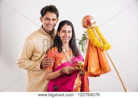smart indian couple in traditional wear performing gudhi padwa puja, asian couple & puja thali, indian young couple with puja or pooja thali, hindu new year gudhi / gudi padwa, isolated on white