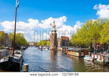 Panorama of Amsterdam with the Montelbaanstoren tower and houseboats along the bank of the canal Oudeschans the Netherlands.