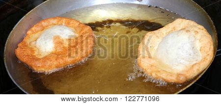 Two Sweet Pastry Frying In Very Hot Oil
