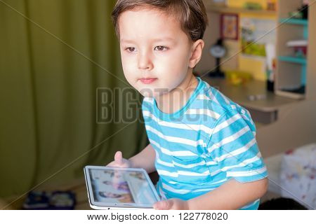 Boy playing with a tablet in hisroom