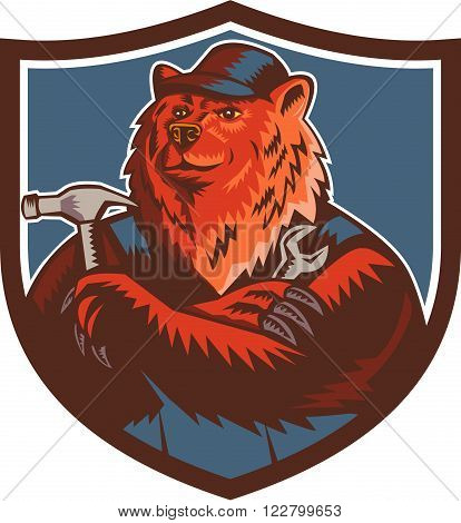 Illustration of a builder handyman Russian bear or Eurasian brown bear wearing hat arms folded with tools hammer and wrench facing front set inside crest shield done in retro woodcut style.