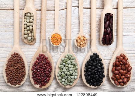 Lentils, Peas And Beans On Wooden Spoons.