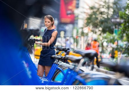 City bike rental/sharing/pooling - woman taking public city bicycle (color toned image; shallow DOF)