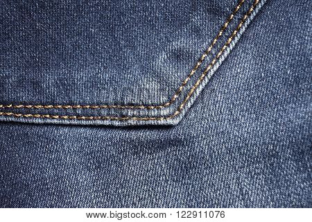 Blue jeans back pocket detail. Textile background
