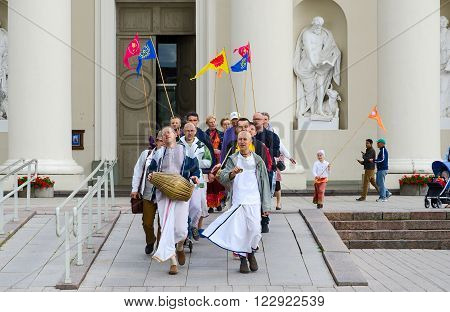 VILNIUS LITHUANIA - JULY 10 2015: Group of Krishnas goes on Cathedral Square of Vilnius near the Cathedral of St. Stanislaus and St. Vladislav