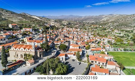 Aerial bird's eye view of Kalavasos village valley, Larnaca, Cyprus. A traditional town with ceramic roof tiles a greek orthodox christian church and muslim mosque around hills from above.