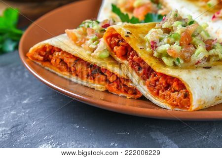 Traditional Mexican dish - chimichanga. Corn cake with minced meat, pepper, onion, garlic, oregano, zira and guacomole sauce from avocado