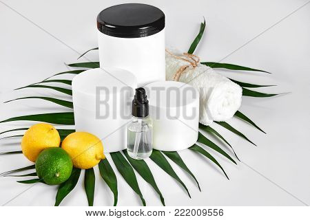 White bottles and two whole lemon and lime isolated on white background. The concept for advertising cosmetics. Still life. Copy space