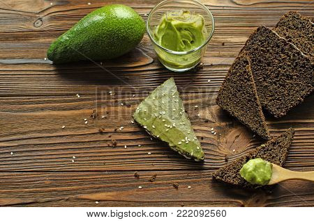 sandwiches with avocado paste on wooden table