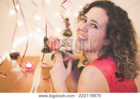 Portrait beautiful woman smile with a pink rose at restaurant on Valentines Day
