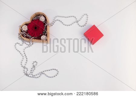 wooden box heart shape with beads and flower gerberas and red box and other items on a white background