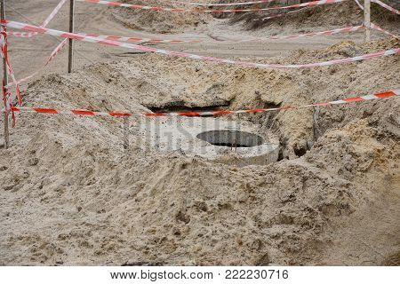 road works with a pile of land and a concrete drainage hatch