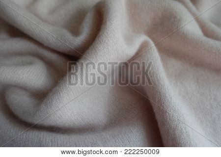 Soft folds on  white woolen knitted fabric