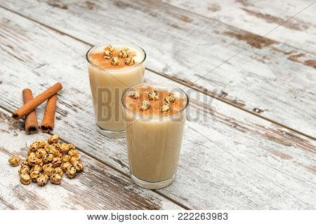 Traditional Turkish drink called Boza with cinnamon sticks and chick-pea on table. 