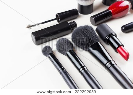 Make-up brushes laying on colorful cosmetic palette. Close up.