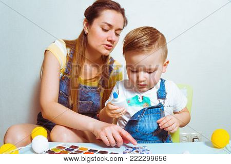 kid with mother making paper bunnies for easter together