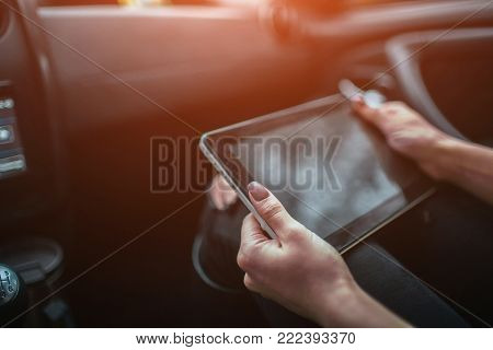 Women using gps on tablet compter to navigate in car on holiday.