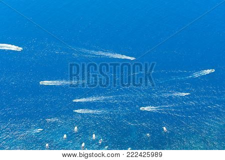 Tyrrhenian Sea waters glimming with sunlight and floating boats, aerial view , Capri island, Italy