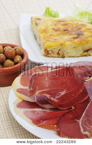 Některé španělské tapas, jako tortilla de patatas, serrano šunka a olivami