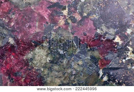 red and black eudialyte mineral texture macro