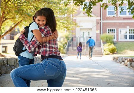 Mother Dropping Off Daughter In Front Of School Gates