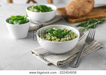 Dish with delicious spinach risotto on table