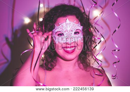 Woman wearing carnival mask at masquerade party. Close up.