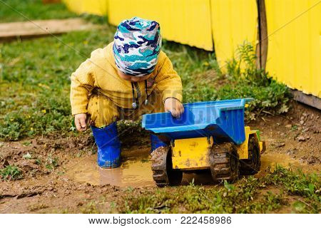 the boy in the street playing with a toy car