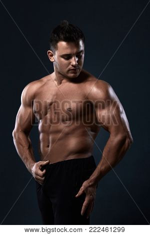Muscular Bodybuilder Doing Exercises With Dumbbell Over Black Background.strong Athletic Man Shows B