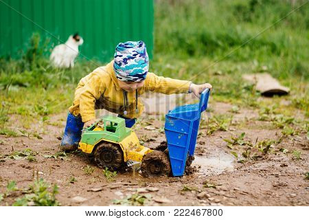 the boy in the street playing with a toy car