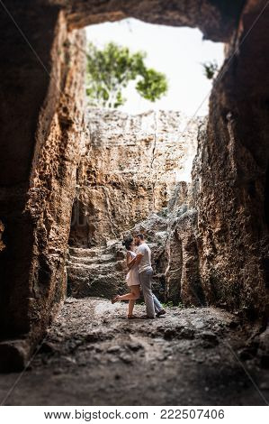 Couple in love kissing in a cave. Guy and girl kissing. The couple in the cave. A lonely loving couple. Man and woman