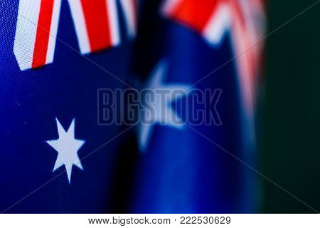 closeup of some australian flags against a dark green background