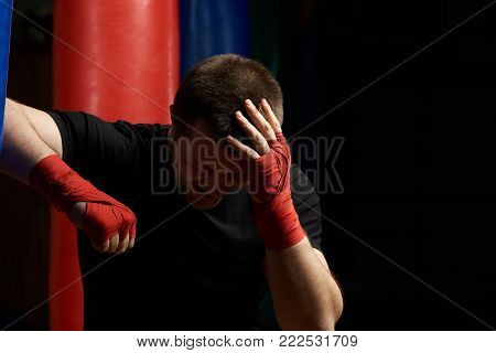 Boxing man holding head in pain after injury. Head  injury theme