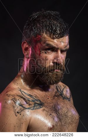 Hipster with beard, mustache on serious dirty face. Bearded man with tattoo on chest skin. Wizard, sorcerer, warlock. Magic, enchantment, witchcraft. Halloween, holidays celebration.