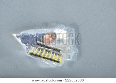 Winter season driving - scraping ice from a windshield. Photo has been taken from the inside of the car