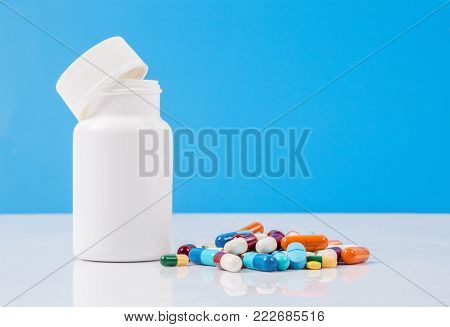 The white plastic bottle and mixed pills.