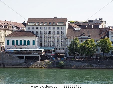 BASEL, SWITZERLAND EUROPE on JULY 2017: Bank on Rhine River in swiss city center with representative historical buildings and restaurants, clear blue sky in warm sunny summer day.