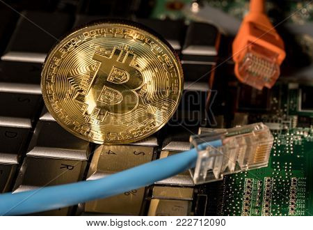 Single bitcoin coin standing on the keyboard by the dollar key