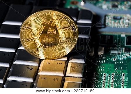 Single bitcoin coin standing on the keyboard by the dollar key