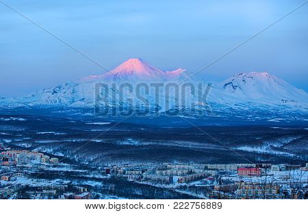 Panoramic view of the city Petropavlovsk-Kamchatsky and volcanoes: Koryaksky Volcano, Avacha Volcano, Kozelsky Volcano. Russian Far East, Kamchatka Peninsula.
