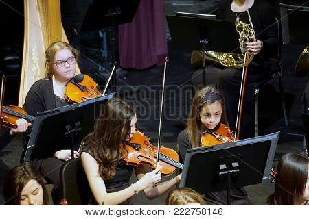 JOLIET, ILLINOIS / UNITED STATES - MARCH 20, 2016: Violinists of the Metropolitan Youth Symphony Orchestra (MYSO) perform music in a concert in the Fine Arts Theater of Joliet Junior College.
