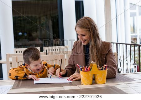 mom and young boy draw colored pencils 