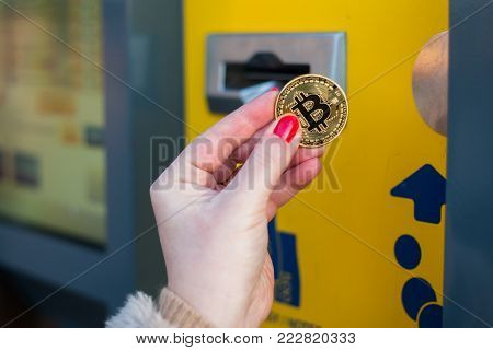 Woman pay with gold bitcoin at the vending machine