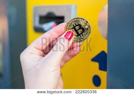 Woman pay with gold bitcoin at the vending machine