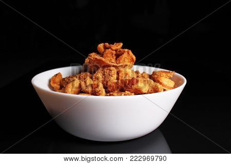 Cracklings greaves. Delicious crunchy crisp cracklings pork greaves on black reflective studio background. Isolated black shiny mirror mirrored background for every concept. Cracklings.