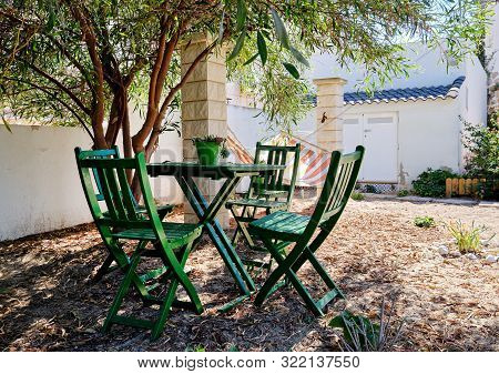 Pretty Inner Yard With Comfortable Green Color Table And Chairs Under Lush Green Tropical Tree And H