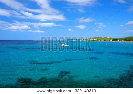 View On The Beach Son Bou, Amazing Water Colours And White Boat On The Balearic Island Menorca, Spai