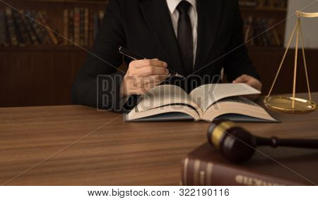 Legislation, Legal, Law Concept. Attorney Or Lawyer Reading Law Books To Advice Client.